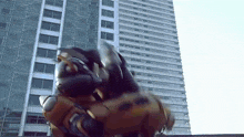 a giant robot is standing in front of a tall building