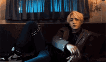 a man is sitting on a couch smoking a cigarette