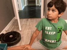 a young boy wearing a green shirt that says eat sleep minecraft