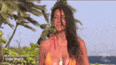 a woman in a bikini stands in front of palm trees with the words ultima spiaggia written on the bottom