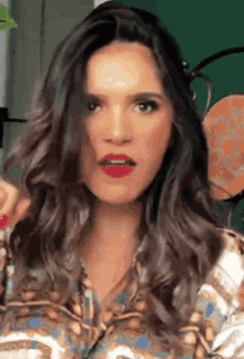a woman with long hair and red lipstick is making a face .