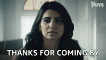 a woman says " thanks for coming by " in front of a poster for the boys