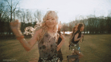 a group of women are dancing in a field with the words aespagifs in the corner