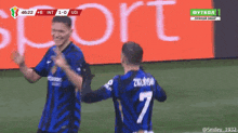 two soccer players on a field with the number 7 on the back
