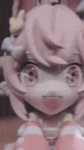 a close up of a doll with pink hair and a bunny ears .