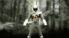 a power ranger in a gray and gold uniform is standing in the woods