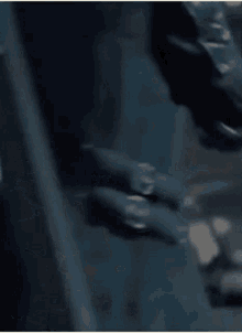 a man in a jacket is holding a sword in his hand .