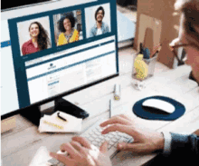 a man is typing on a keyboard in front of a computer screen with a group of people on it