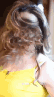a woman in a yellow dress has her hair in a ponytail and the word united is on the bottom