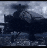 a helicopter is flying over a city with a cloudy sky in the background .
