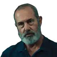 a man with a beard and a blue shirt is looking at the camera