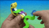 a person is holding a toy in their hands that looks like a snake