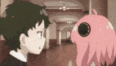 a boy and a girl are standing next to each other in a hallway .