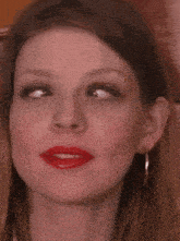 a close up of a woman 's face with red lipstick on .