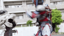 a man in a superhero costume is fighting another man .