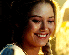 a close up of a woman 's face with a braid smiling