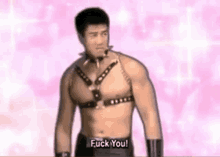 a shirtless man wearing a leather harness is standing in front of a pink background and says `` fuck you '' .
