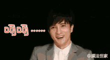 a man in a suit is smiling with chinese writing above his head