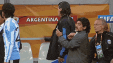a group of people standing in front of a sign that says " argentina "