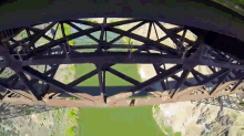 an aerial view of a bridge over a river with people walking on it