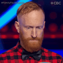 a man with a beard is wearing a bow tie and plaid shirt