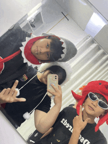 a man wearing a shark hat takes a selfie with another man wearing a crab hat