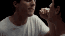 two men are touching each other 's faces in a mirror .