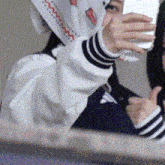 a woman wearing a scarf is taking a selfie with her cell phone