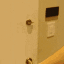 two men are peeking out from behind a door and smiling .