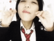 a girl in a school uniform and tie is making a face .