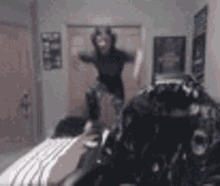 a person is jumping on a bed in a bedroom .