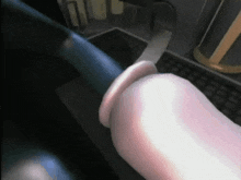 a close up of a person 's hand holding a blue object in front of a keyboard