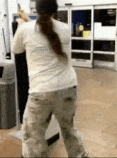 a woman in a white shirt and khaki pants is standing in front of a store