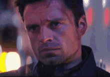 a close up of a man 's face in a dark room with a blurred background .
