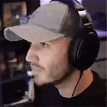 a man wearing headphones and a hat is looking at something .