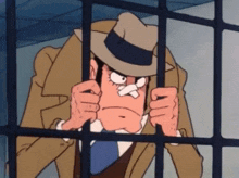 a man in a hat is behind bars and making a face