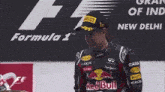 a man holding a trophy with the word red bull on it