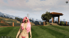 a woman in a bikini with pink hair is standing in a grassy area