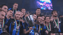 a group of soccer players are posing with a trophy and medals