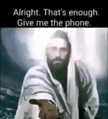 jesus is reaching out his hand towards the camera and saying alright that 's enough give me the phone .