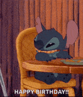 stitch from lilo and stitch is sitting at a table eating a sandwich .