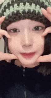 a girl wearing a knitted hat is making a funny face