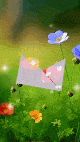 a white envelope with a heart on it is surrounded by colorful flowers
