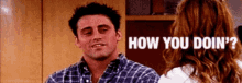 a man in a plaid shirt is talking to a woman in a kitchen and the woman is asking how you doin ?