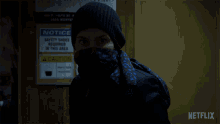a person with a scarf around their face and a netflix logo