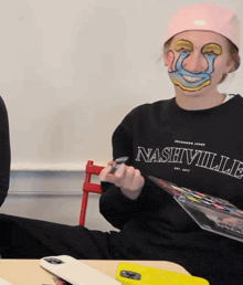 a person wearing a nashville sweatshirt is sitting at a table