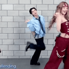 a man and a woman are dancing in front of a wall .