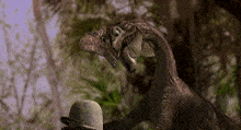 a dinosaur wearing a hat is standing next to a tree