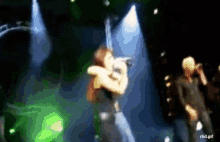 a blurry picture of a woman singing into a microphone