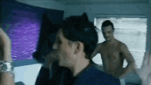 a group of men are dancing in a room with a purple wall .
